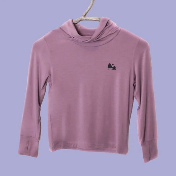 Pink long-sleeve shirt with a logo on a hanger against a purple background
