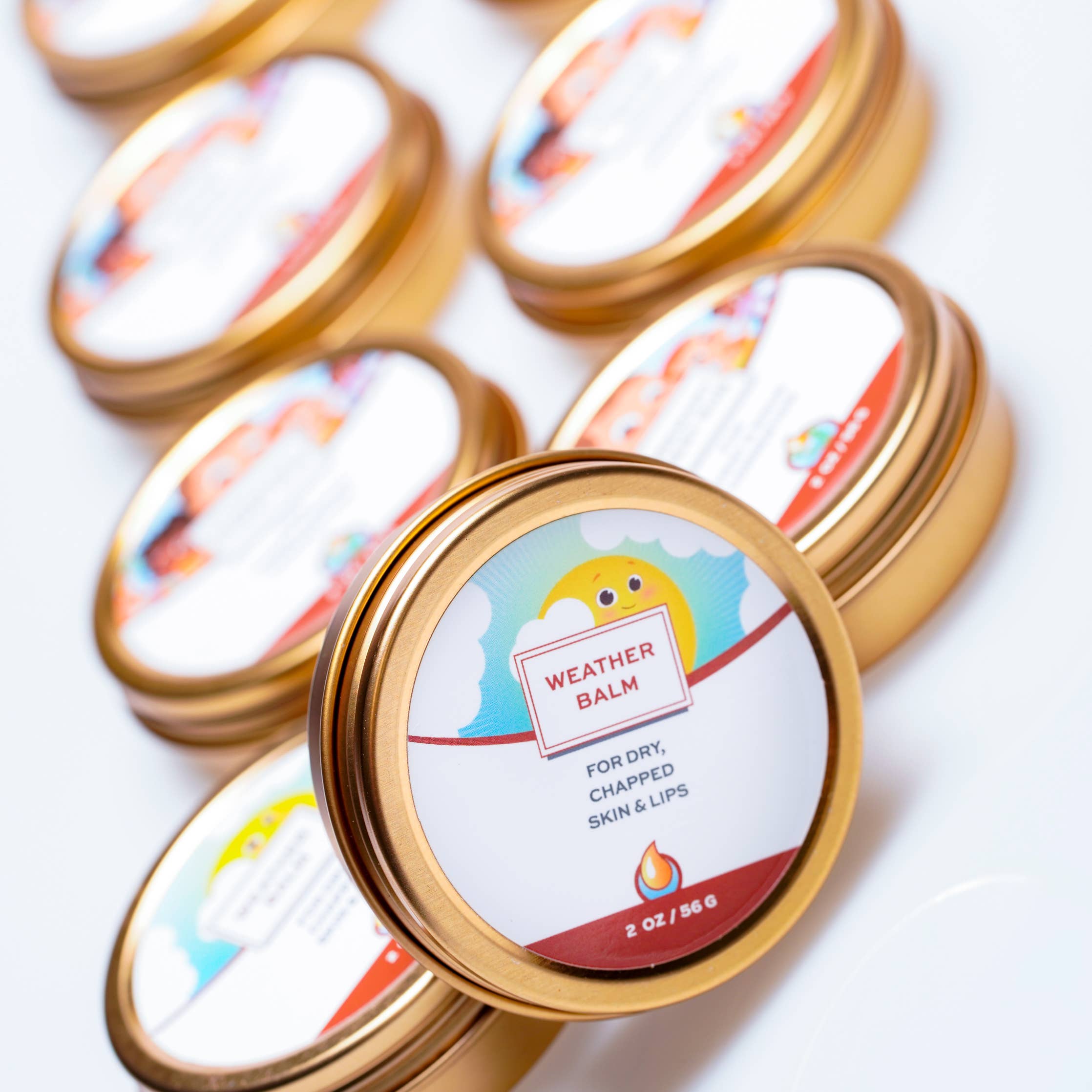 Multiple tins of 'Weather Balm' on a white background