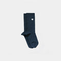 A pair of dark blue heathered crew socks with a small white circular logo on the upper cuff, displayed against a solid light gray background.