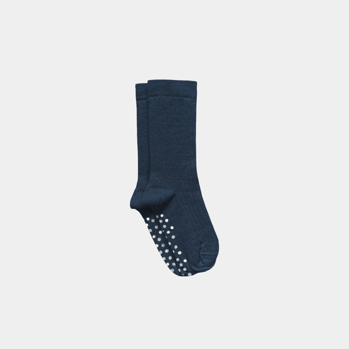 A pair of dark navy blue crew socks with white grip dots on the soles, shown against a light gray background.