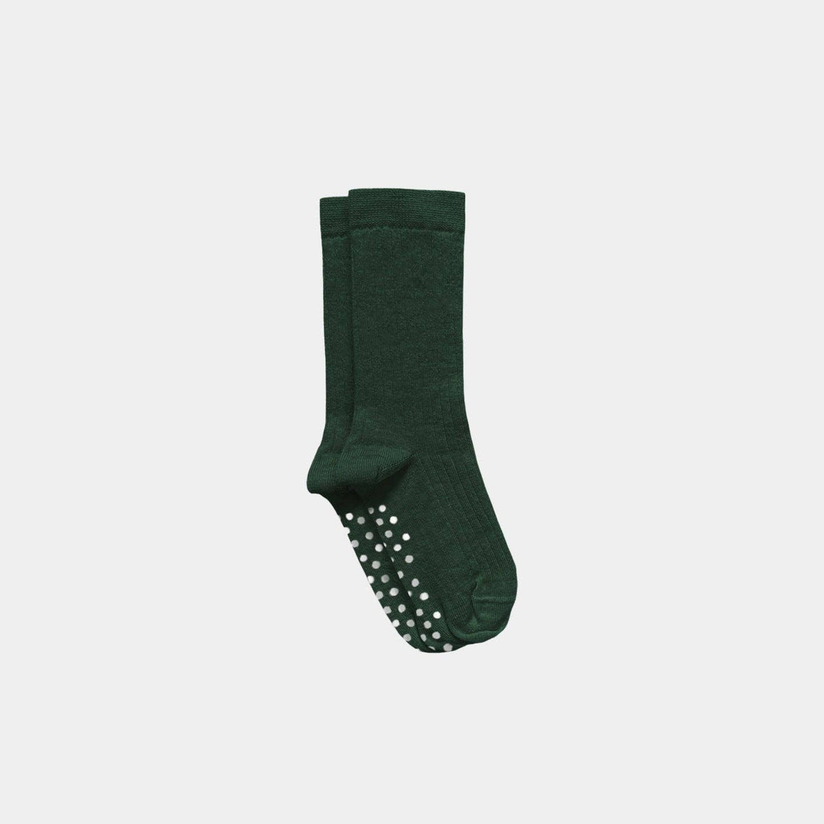 A pair of dark green crew socks with white grip dots on the soles, shown against a light gray background.