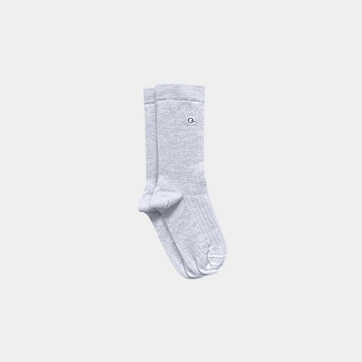 A pair of light heather gray crew socks with a small circular embroidered logo on the upper leg, displayed against a solid light gray background.
