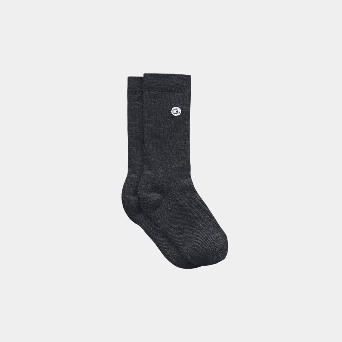 A pair of dark charcoal gray ribbed crew socks with a small white circular logo on the side, displayed against a solid light gray background.