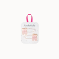 A set of two hair clips shaped like pink ballet slippers, attached to a white display card with a pink handle. The card is branded with the name 'Rockahula' and is photographed against a solid off-white background.