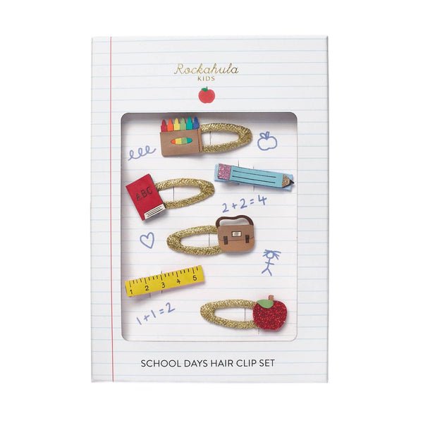 Rockahula Kids School Days Hair Clip Set in a lined notebook-style package window display, featuring multiple gold glitter hair clips shaped like school supplies and objects.