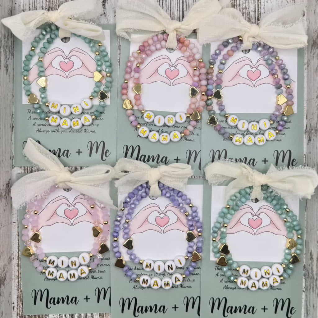 Set of six decorative items with 'Mama + Me' text on a wooden surface