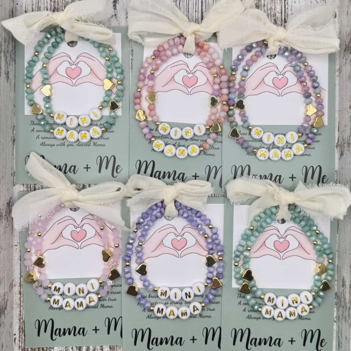 Set of six decorative items with 'Mama + Me' text on a wooden surface
