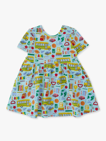 A short-sleeve baby dress with a light blue background and a colorful school-themed print featuring yellow school buses, books, apples, pencils, and numbers.