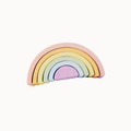 A pastel rainbow wooden toy with five nested semi-circular arches in pink, orange, yellow, mint, and lavender, shown on a plain off-white background.
