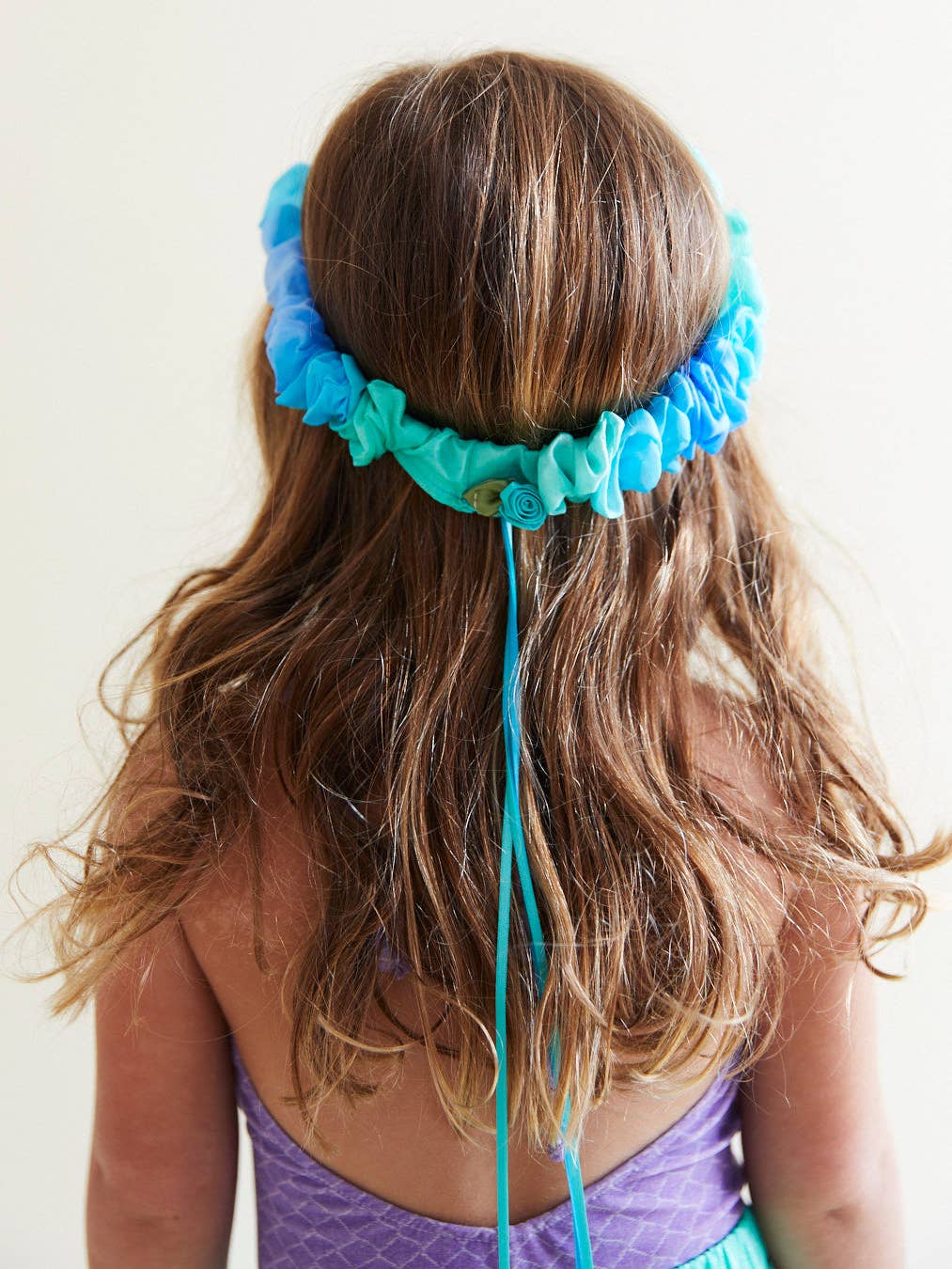 Blue silk headband with rose and ribbons on a girl's head