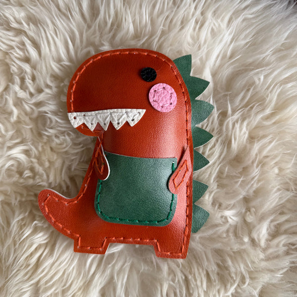Dinosaur-shaped pouch on a fluffy white surface