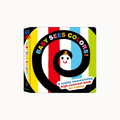 Baby Sees Colors! board book with a colorful spiral design on the cover, featuring bold vertical stripes in yellow, black, red, white, blue, and green, and a cartoon face inside the spiral.