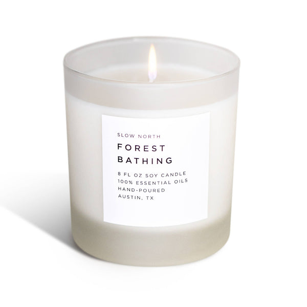 Frosted candle with a label reading 'Forest Bathing' on a white background