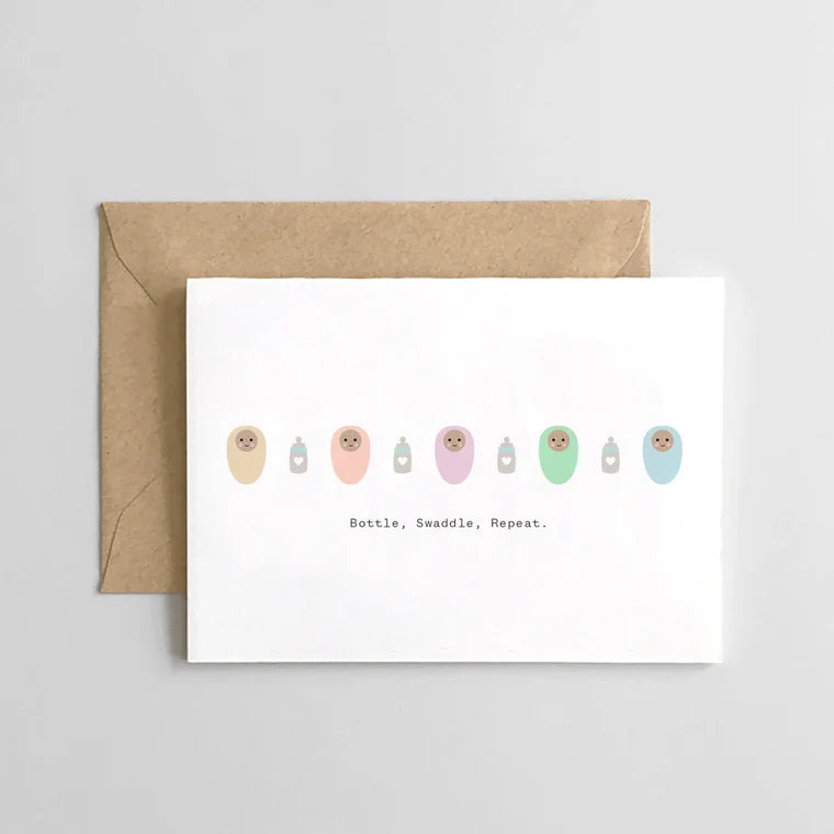 swaddled babies with bottles on white card on brown envelope