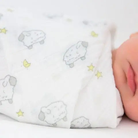 Baby swaddled in a blanket with animal prints and stars