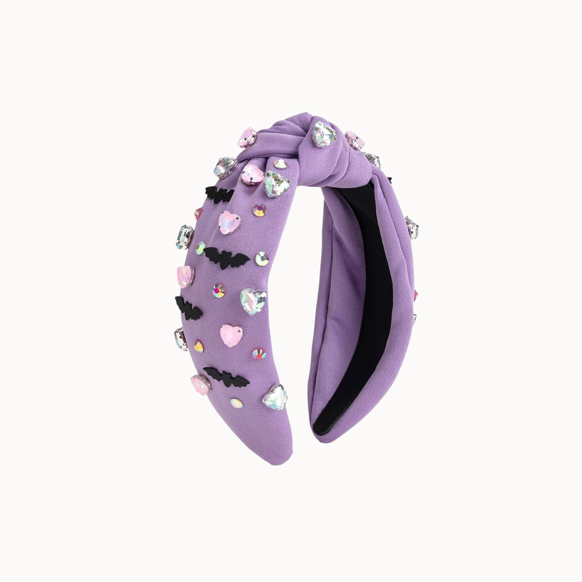 A lavender purple velvet twist headband decorated with small pink and black heart charms, rhinestones, and bat-shaped embellishments, shown against a plain off-white background.