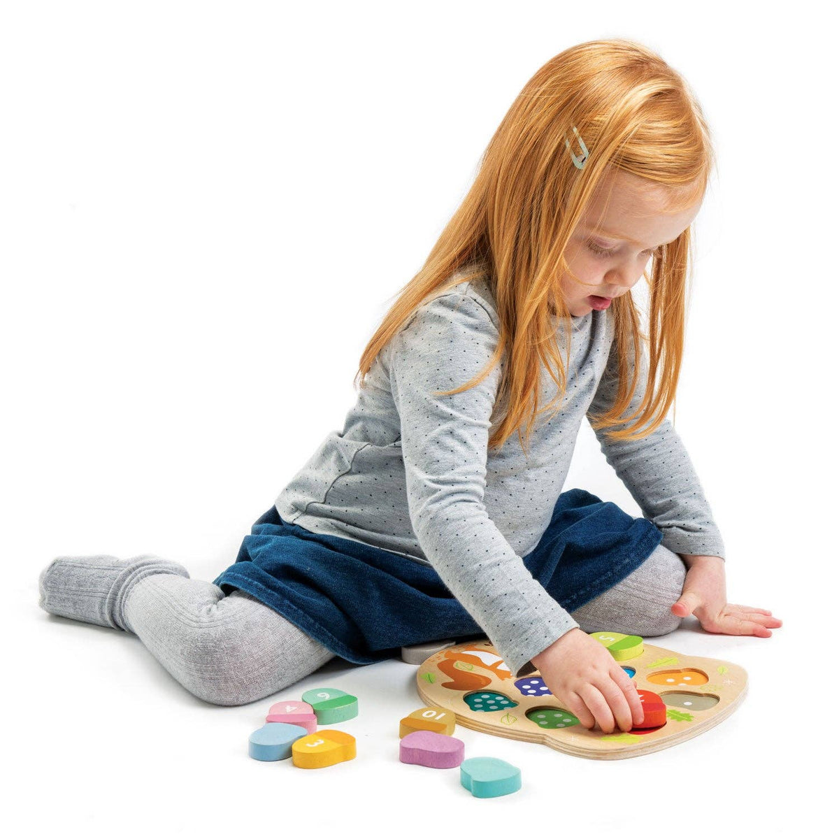 Child playing with a colorful wooden puzzle on a white background