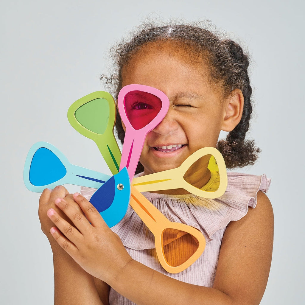Child holding colorful toy against a light gray background