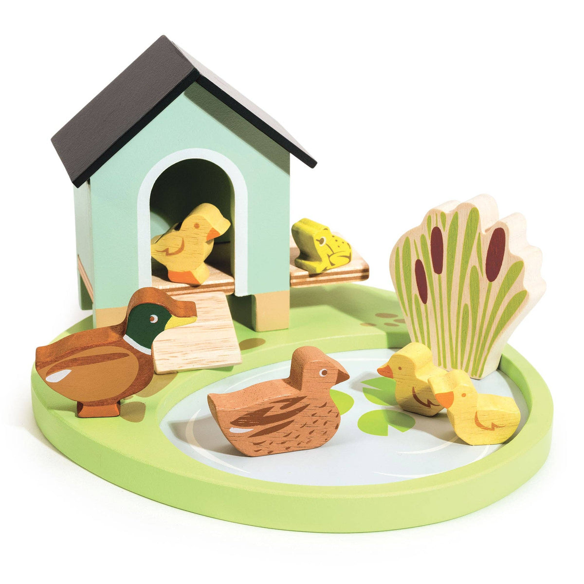A wooden toy farm scene on a round base, featuring a small house, ducks, chicks, a frog, reeds, and a duckling, photographed on a white background.
