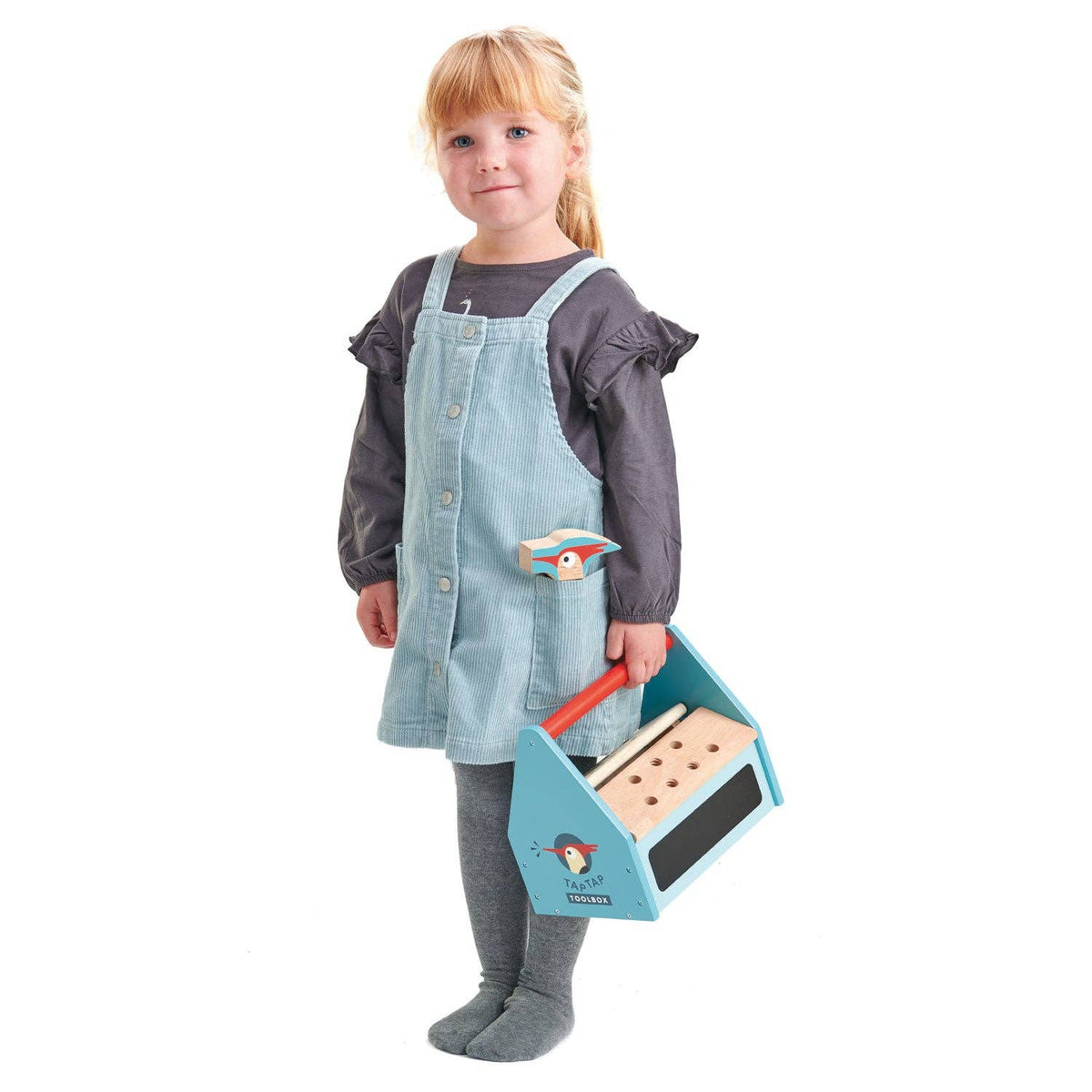 Child wearing a denim apron holding a toy tool set on a white background