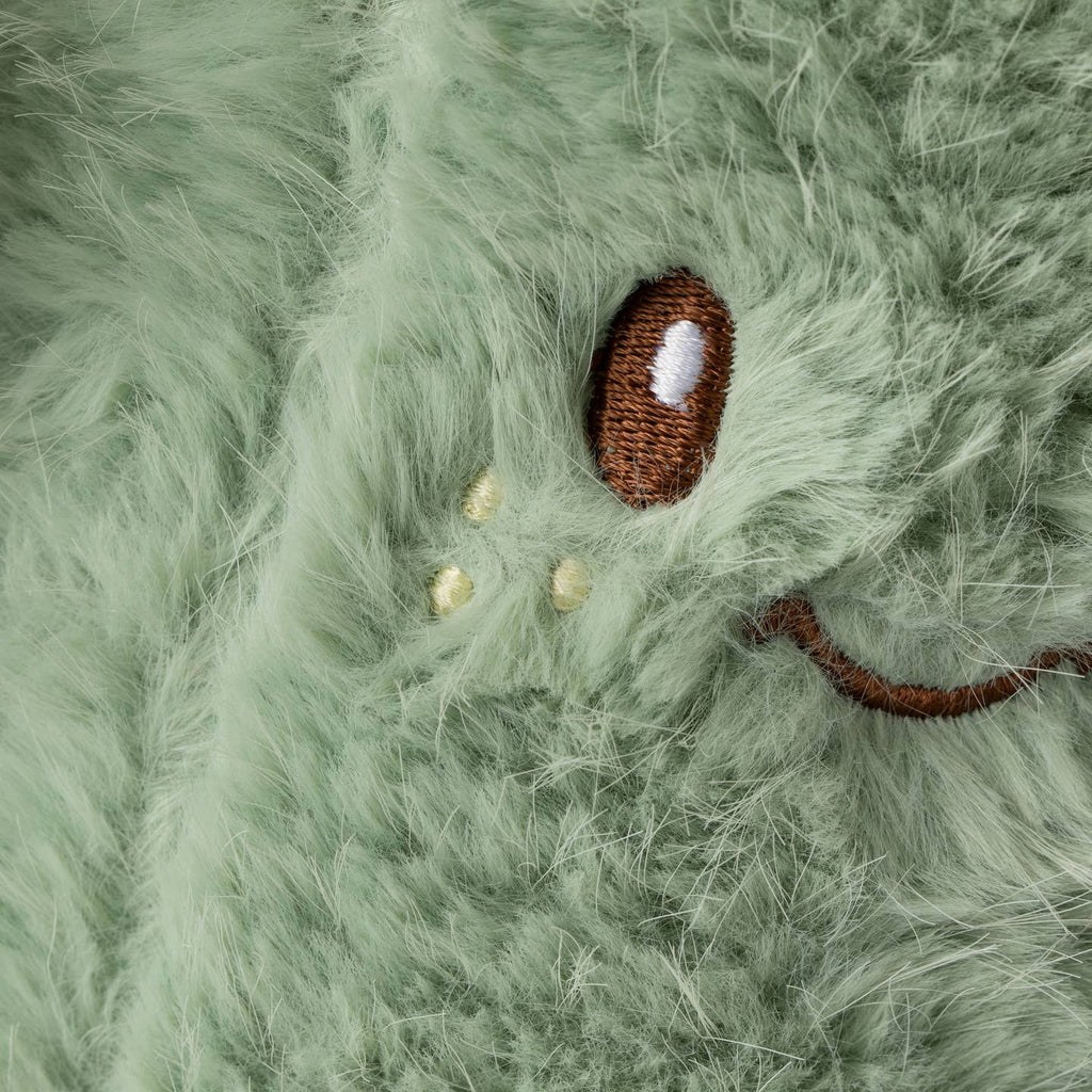 Small brown and white object on a green fluffy surface