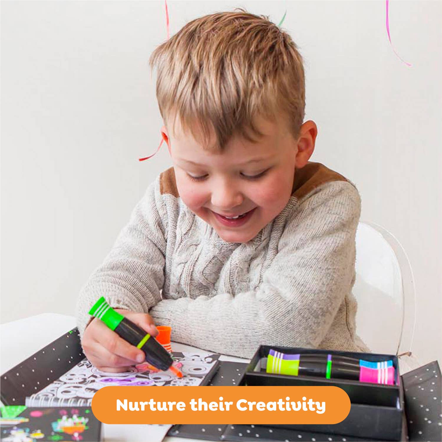 Child drawing with markers on a table, with text 'Nurture their Creativity' at the bottom.