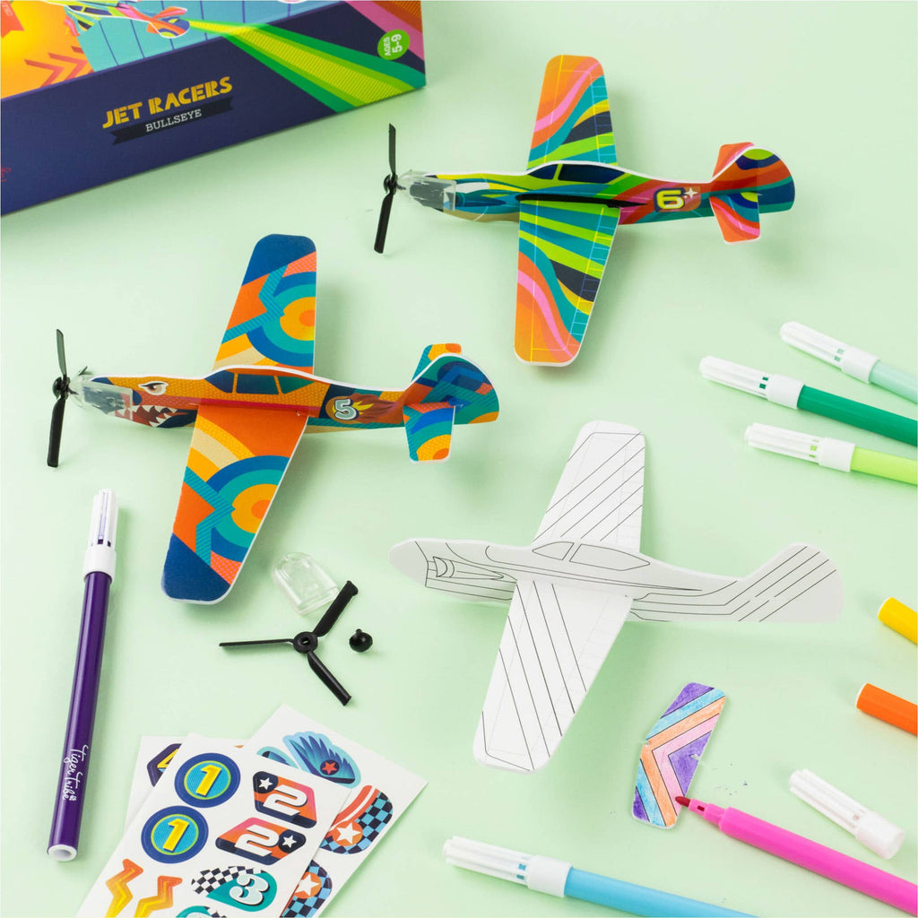 Colorful toy planes with construction paper cutouts and markers on a light green background