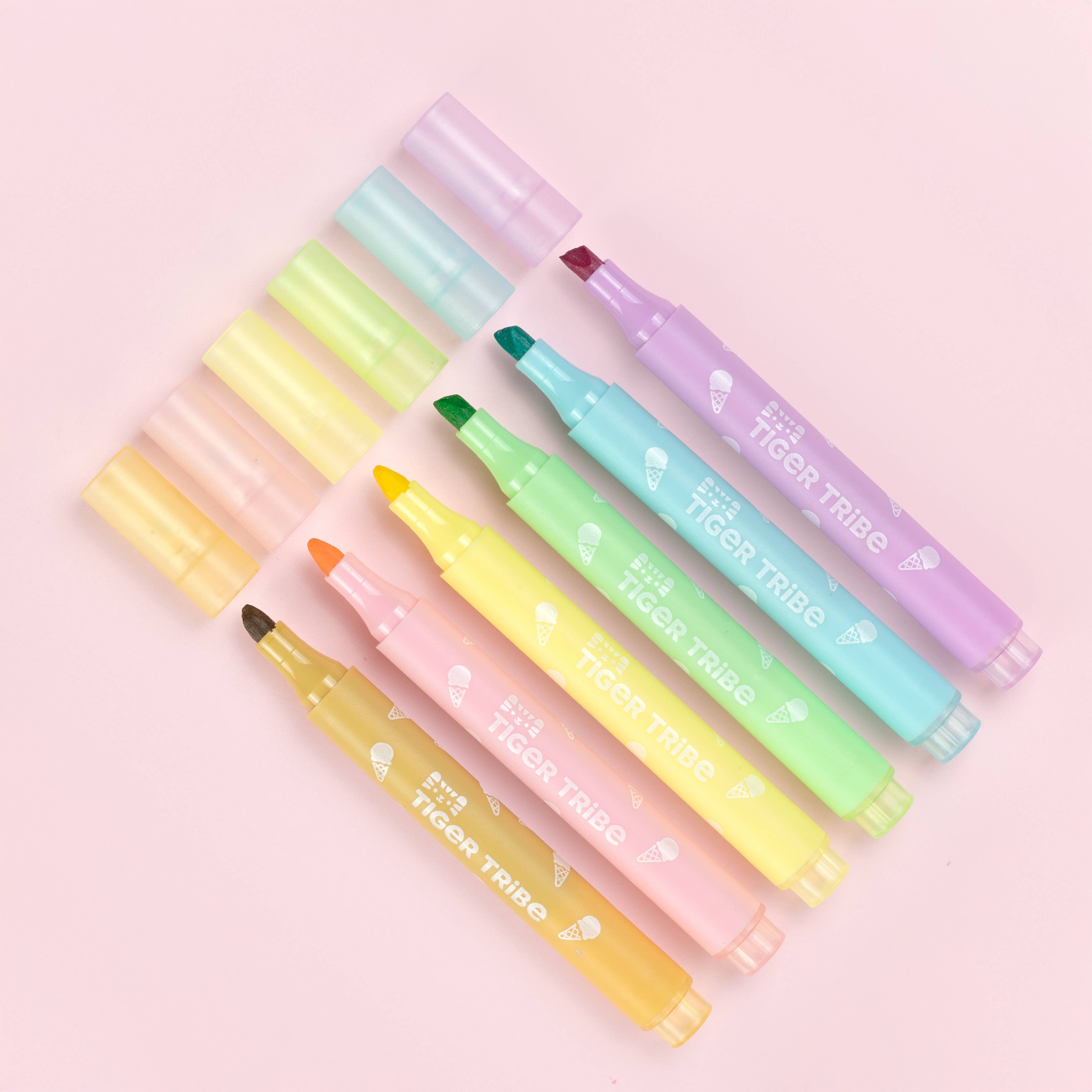 Set of colorful highlighters with visible brand name on a pink background