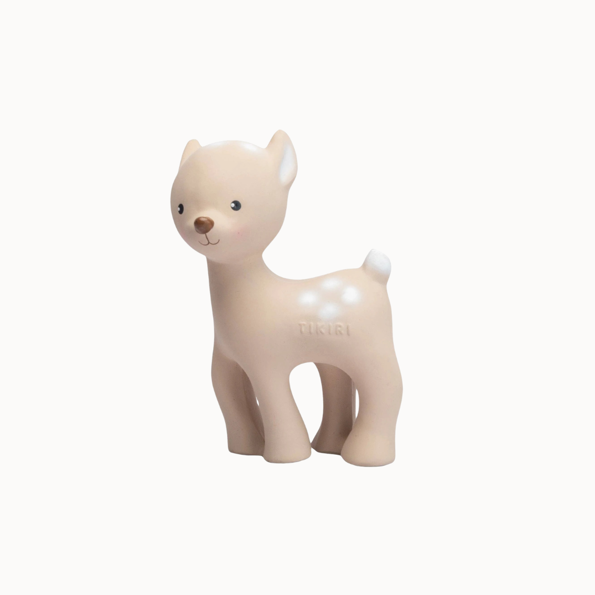 A small toy dachshund figurine in a warm cream-beige color with white spots, standing on a solid off-white background. The brand name 'Tikiri' is subtly embossed on the side of its back.