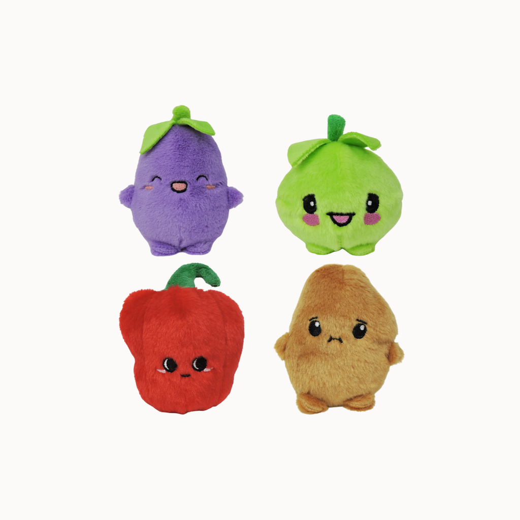 Four cute plush fruit toys arranged in a 2x2 grid on a plain white background. The top-left plush is a purple eggplant with a green leafy top, the top-right is a green pear with a green stem, the bottom-left is a red pepper with a green stem, and the bottom-right is a brown potato with a sad expression.