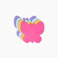 A butterfly-shaped baby teether or chew toy made of layered, wavy silicone in pink, yellow, light blue, and purple, shown on a plain off-white background.
