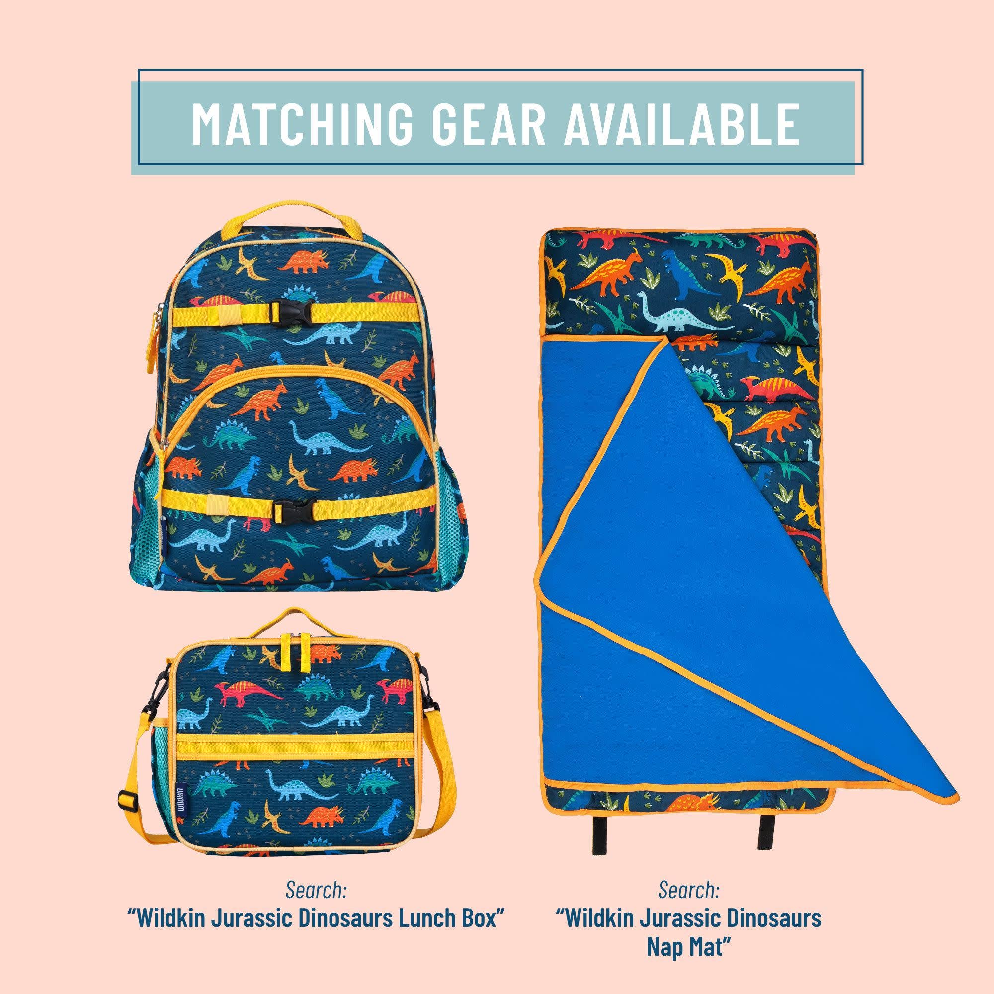 A matching dinosaur-themed children's gear set displayed on a pale pink background, including a backpack, lunch box, and nap mat. The items feature a dark blue base with a colorful print of dinosaurs in orange, yellow, green, and blue, accented with bright yellow trim.