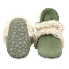 Green slippers with white fur lining on a white background