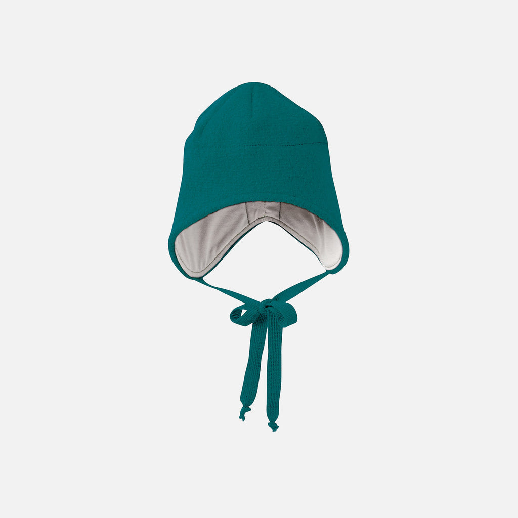 A teal Disana boiled wool hat with ties for adjustment, displayed against a white background.