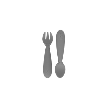 Packaged mini utensils consisting of a fork and spoon designed for toddlers, with a gray color and sensory features.
