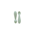 Two green silicone spoons designed for babies, with wide handles and narrow bowls.