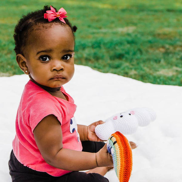 baby holding rainbow toy