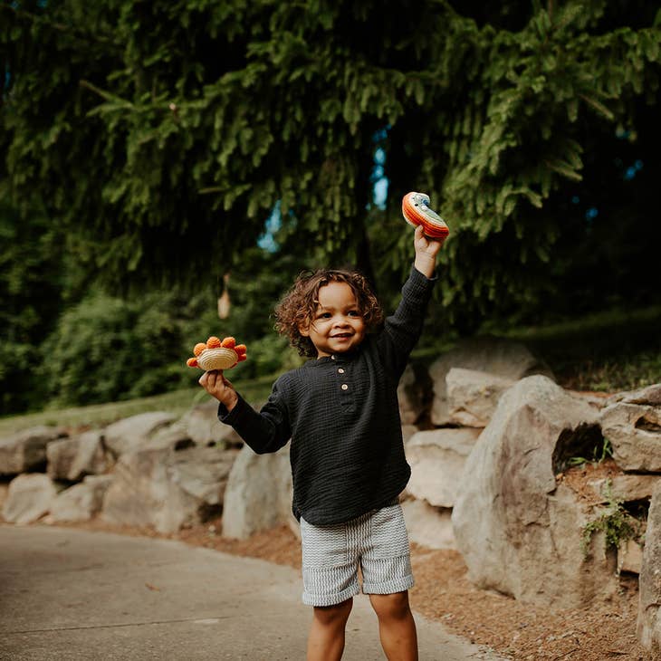 boy holding rainbow and sun toys