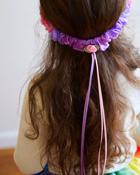 Rainbow silk heading bad with flower and ribbon on a girl's head